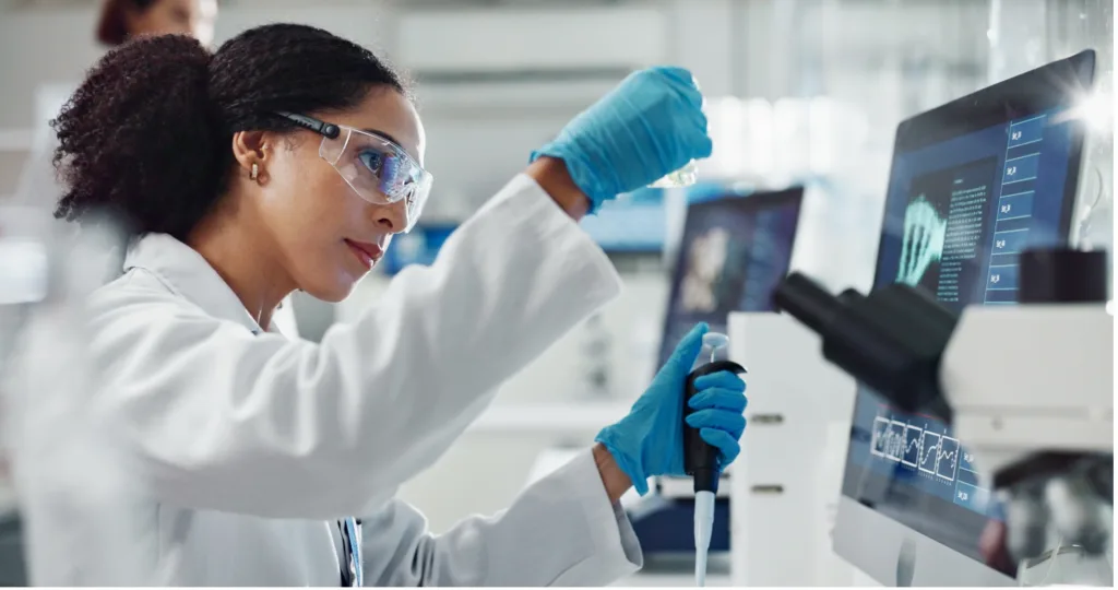 Woman scientist using test tube and dropper in research lab.