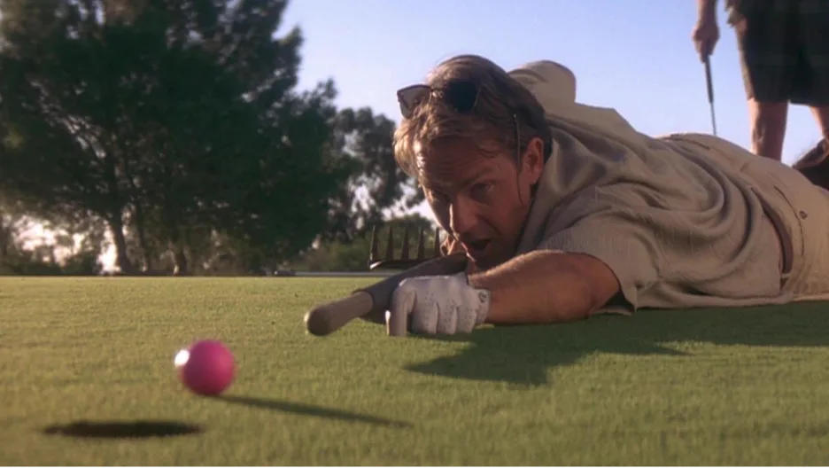 Image of a man making a golf putt from a scene in Tin Cup. 