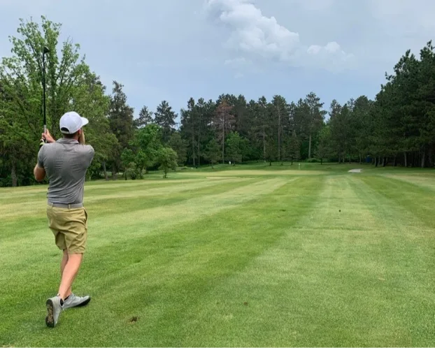 Man playing golf on golf course. 
